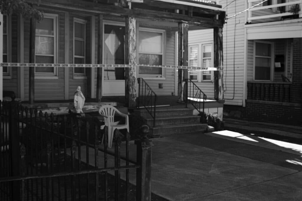 grayscale photo of woman sitting on chair near window