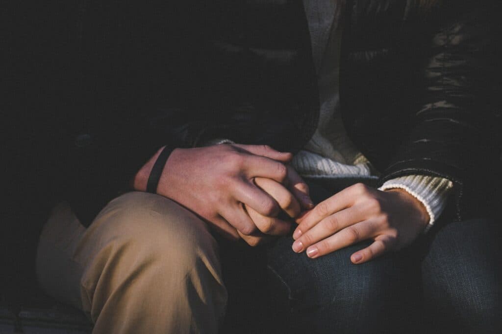 a close up of two people holding hands