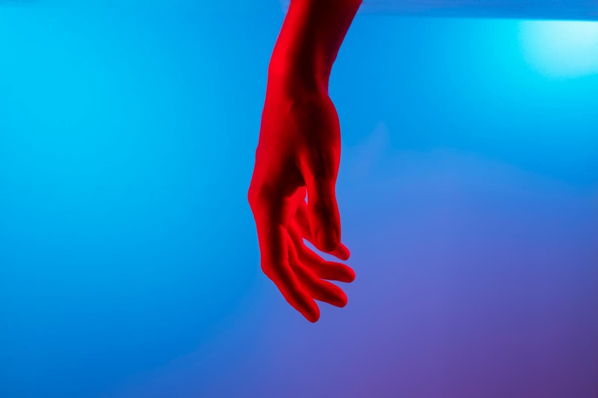 persons left hand on blue surface