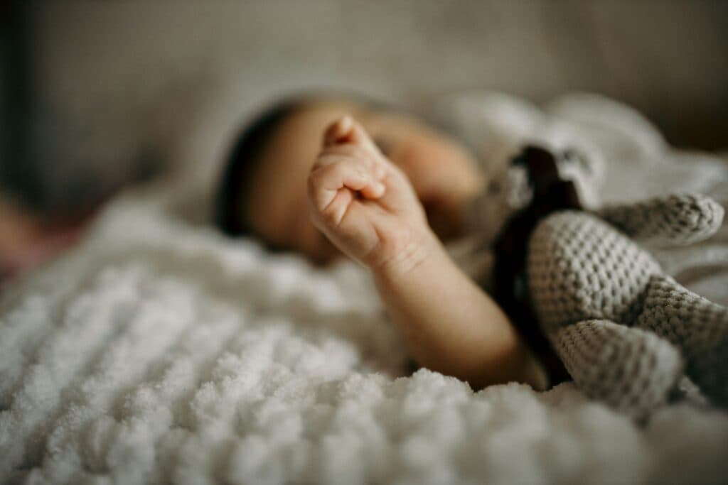 a close up of a baby laying on a blanket